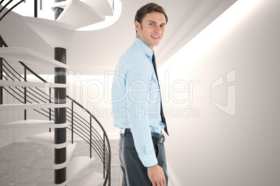 Composite image of happy businessman standing with hand in pocke