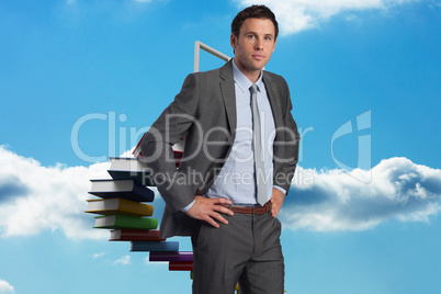 Composite image of serious businessman with hands on hips