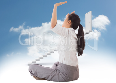 Composite image of businesswoman sitting cross legged pushing up