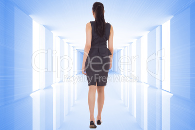 Composite image of businesswoman walking