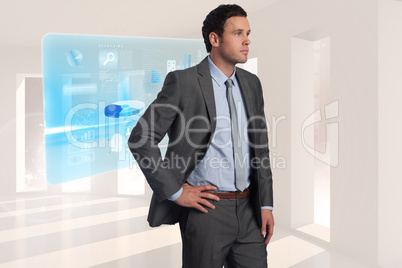 Composite image of businessman with hand on hip