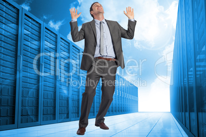 Composite image of businessman posing with arms raised