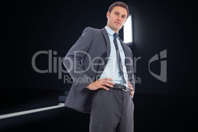 Composite image of stern businessman with hands on hips