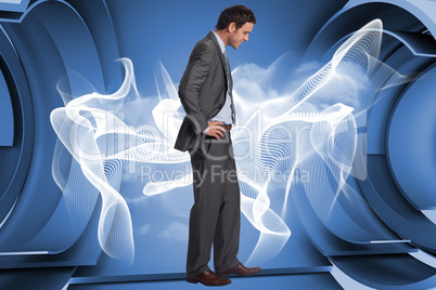 Composite image of smiling businessman with hands on hips