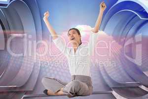 Composite image of businesswoman sitting cross legged cheering