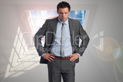 Composite image of serious businessman with hands on hips