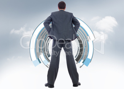 Composite image of businessman standing with hands on hips