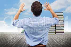 Composite image of businessman posing with arms raised