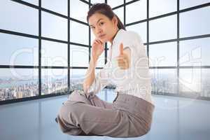 Composite image of businesswoman sitting cross legged showing th