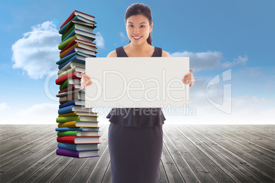 Composite image of businesswoman holding a placard