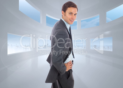 Composite image of cheerful businessman standing with hands on h