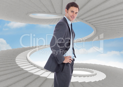 Composite image of smiling businessman with hands on hips