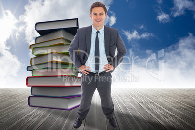 Composite image of cheerful businessman standing with hands on h