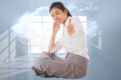 Composite image of businesswoman sitting cross legged showing th