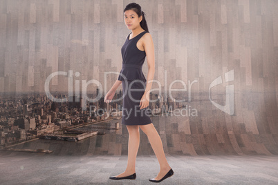 Composite image of asian businesswoman walking