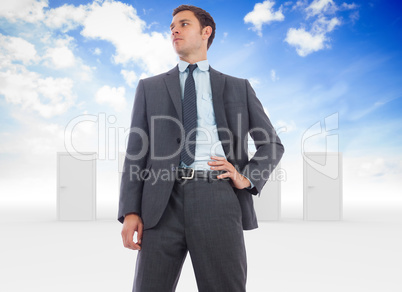 Composite image of stern businessman with hand on hip