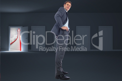 Composite image of happy businessman with hands on hips