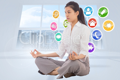 Composite image of businesswoman sitting in lotus pose