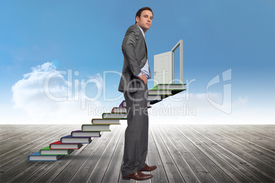 Composite image of serious businessman with hands on hips