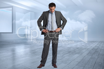 Composite image of serious businessman with hands on hips