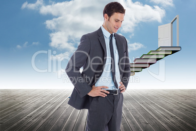 Composite image of smiling businessman with hands on hips