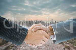 Composite image of business handshake