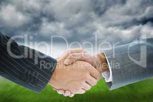 Composite image of business handshake