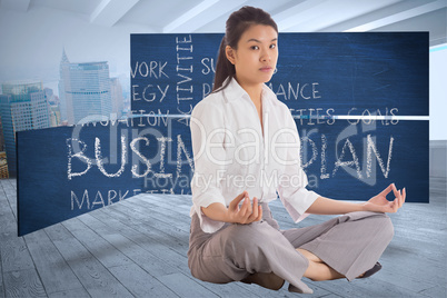 Composite image of businesswoman sitting in lotus pose