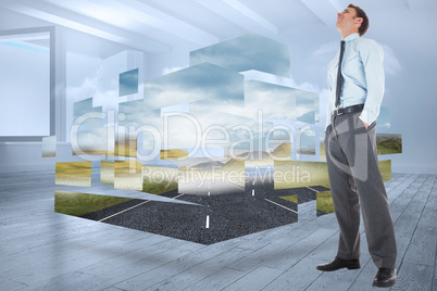 Composite image of happy businessman standing with hands in pock