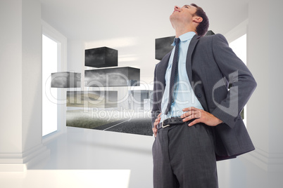 Composite image of cheerful businessman with hands on hips