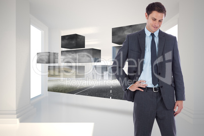 Composite image of smiling businessman with hand on hip