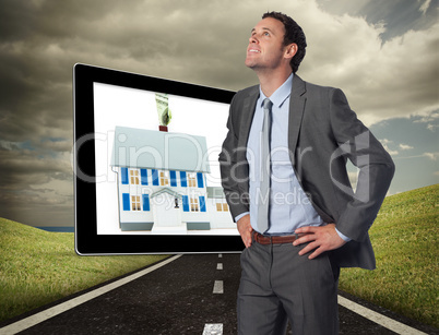 Composite image of smiling businessman with hands on hips