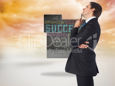 Composite image of thinking businessman holding pen