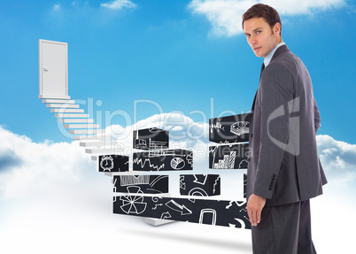 Composite image of serious businessman with hand on hip