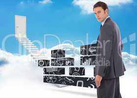 Composite image of serious businessman with hand on hip