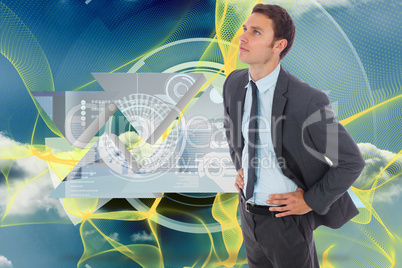 Composite image of serious businessman standing with hands on hi