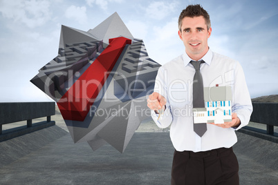 Composite image of businessman holding a key and a miniature hou