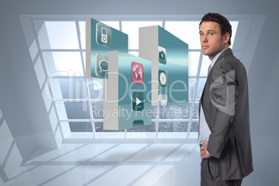 Composite image of serious businessman with hand on hip