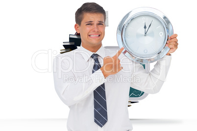 Composite image of anxious businessman holding and showing a clo