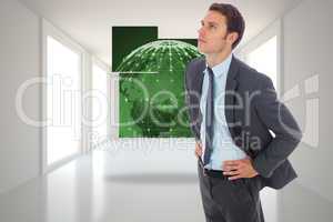 Composite image of serious businessman standing with hands on hi