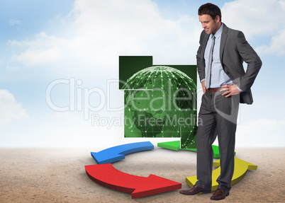 Composite image of smiling businessman with hands on hips