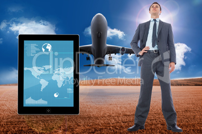 Composite image of serious businessman with hand on hip