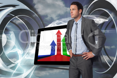 Composite image of serious businessman with hands on hips