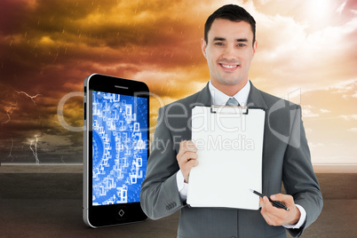 Composite image of businessman pointing with pen on clipboard