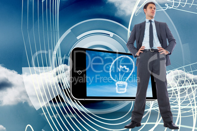 Composite image of serious businessman with hands on hips