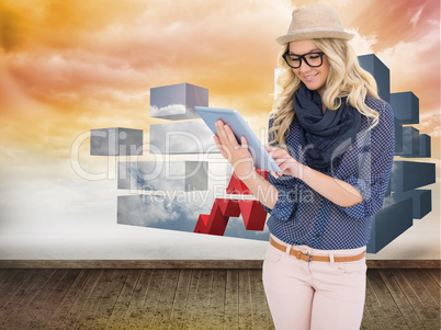 Composite image of smiling trendy blonde using tablet computer