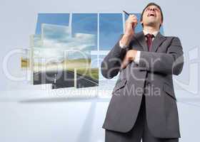 Composite image of thoughtful businessman holding pen