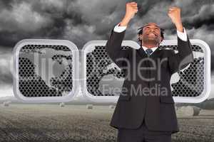 Composite image of happy businessman with raised arms
