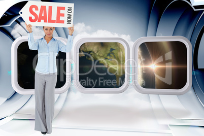 Composite image of businesswoman holding sign above her head