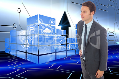 Composite image of serious businessman standing with hand on hip